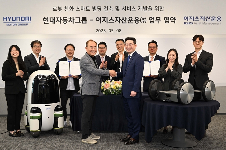 현대차∙기아의 실내외 배송 로봇(왼쪽)과 모베드(MobED, 오른쪽)가 놓인 가운데 김용화 현대차∙기아 연구개발본부장(앞줄 왼쪽)과 정석우 이지스자산운용 리얼에셋부문 대표(앞줄 오른쪽) 등 주요 관계자들이 사진촬영에 임하고 있다. 사진ㅣ현대자동차그룹