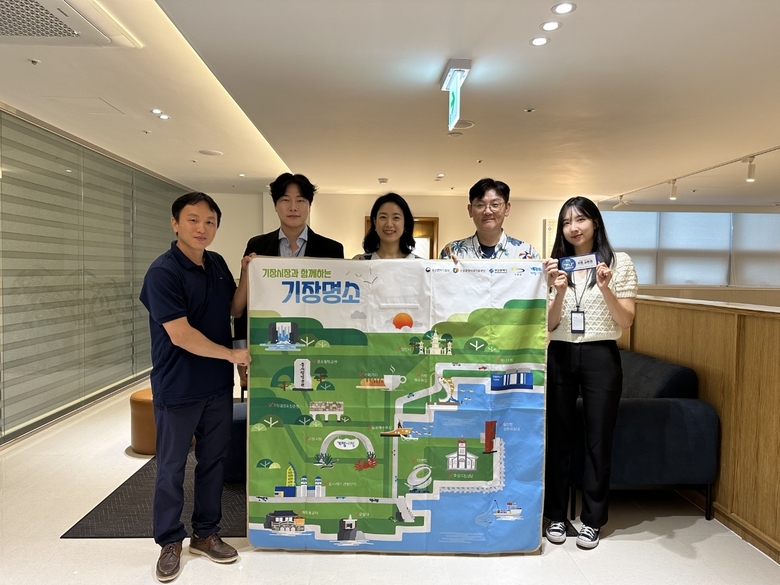 호텔케니 기장점 관계자(사진 맨왼쪽 문정민 대표)들이 부산 기장군 관광명소 지도를 들고 사진촬영에 임하고 있다. 사진ㅣ호텔케니 기장점