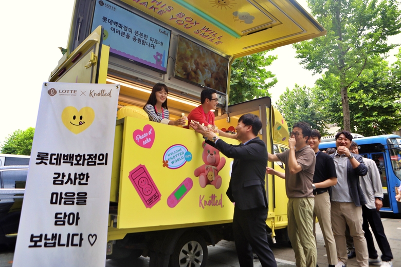 롯데백화점이 마련한 커피차에서 파트너사 임직원들이 간식을 받아가는 모습. 사진ㅣ롯데백화점