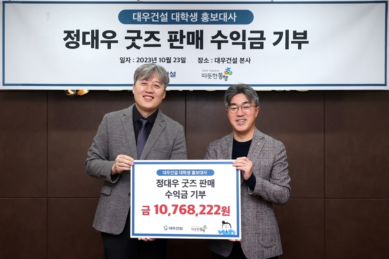 이광재 따뜻한동행 상임이사(사진 왼쪽)와 서희종 대우건설 경영지원담당 상무(사진 오른쪽)가 '대우건설 대학생 홍보대사' 정대우 굿즈 판매 수익금 기부행사에서 사진촬영에 임하고 있다. 사진ㅣ대우건설