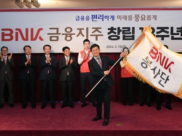 빈대인 BNK금융지주 회장이 창립 13주년 기념식에서 BNK봉사단기를 들어올리고 있다. 사진ㅣBNK금융지주