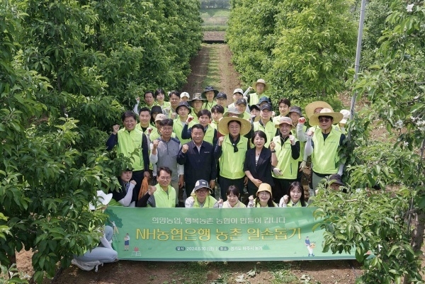 이석용 NH농협은행장(둘째줄 가운데)과 임직원이 파주지역 한 사과재배농가에서 일손돕기활동을 한 뒤 기념촬영하고 있다. 사진ㅣNH농협은행