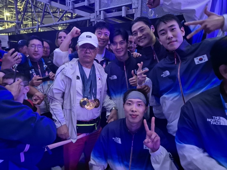 지난달 31일 파리 올림픽 펜싱 사브르 남자 단체전 결승에서 금메달을 따낸 선수들과 기념사진을 찍고 있는 최신원 대한펜싱협회 회장(왼쪽). 사진|SK텔레콤