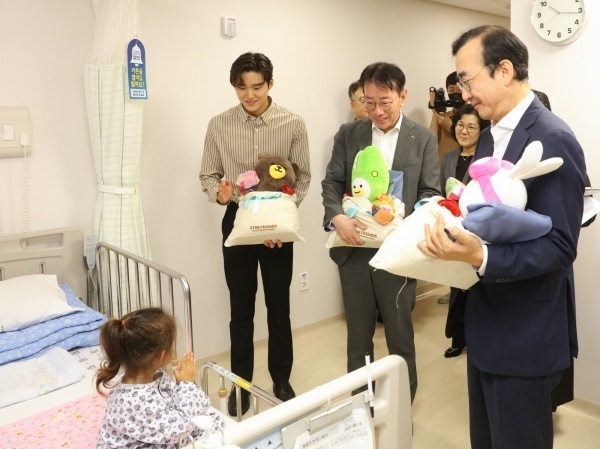 이재근 KB국민은행장(가운데)과 이세훈 금융감독원 수석부원장(오른쪽), KB금융그룹 후원 수영선수 김우민이 부천세종병원에서 입원 환아에게 인형과 전통과자를 선물하고 있다. 사진ㅣKB국민은행