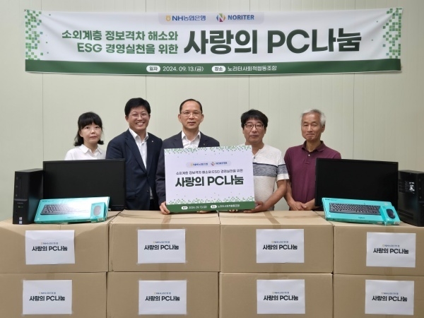 박병규 NH농협은행 수석부행장(가운데)이 허상철 노리터사회적협동조합 이사(왼쪽 네번째)를 찾아 사랑의 PC를 전달한 뒤 기념촬영하고 있다. 사진ㅣNH농협은행