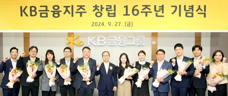 양종희 KB금융그룹 회장(왼쪽 여섯번째)이 27일 KB국민은행 신관에서 임직원 60여명이 참석한 가운데 열린 창립 16주년 기념식에서 장기근속 직원들과 기념촬영하고 있다. 사진ㅣKB금융그룹