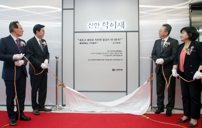 지난 18일 부산시 부산진구에서 문을 연 '신한 학이재 부산' 개관식에서 정상혁 신한은행장(오른쪽 두번째), 박형준 부산시장(왼쪽 두번째), 김미영 금융감독원 금융소비자보호처장(오른쪽), 문우택 대한노인회 부산시연합회장(왼쪽)이 현판제막식을 하고 있다. 사진ㅣ신한은행