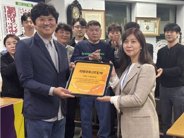 기장군치매안심센터 관계자가 기장읍청년회와 케어링에 치매극복선도단체 지정패를 전달하고 있다. 사진ㅣ기장군 