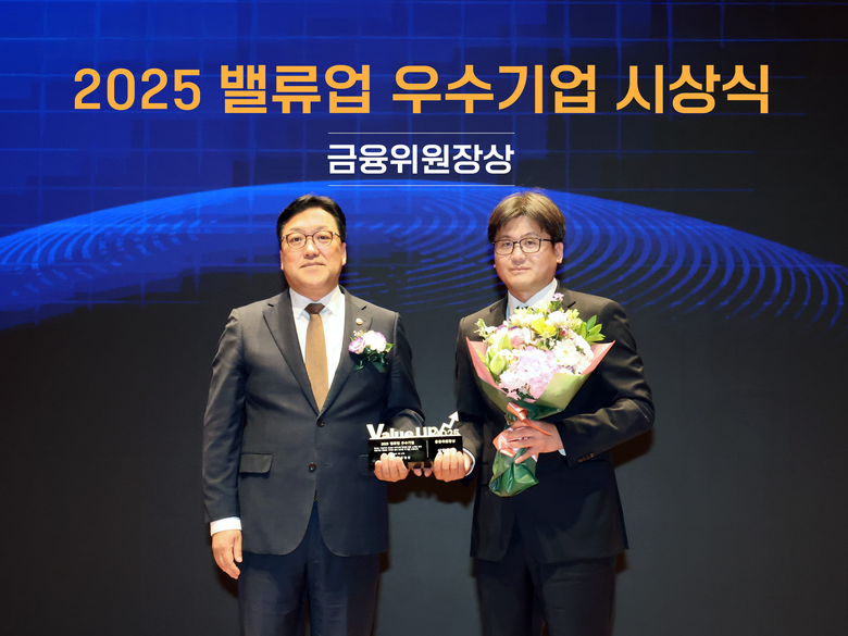 지난 27일 서울 여의도 한국거래소에서 열린 '2025 밸류업 우수기업 시상식'에서 장석훈 삼양식품 경영지원본부장(오른쪽)과 김병환 금융위원회 위원장(왼쪽)이 기념 촬영을 하고 있는 모습. 사진ㅣ삼양식품