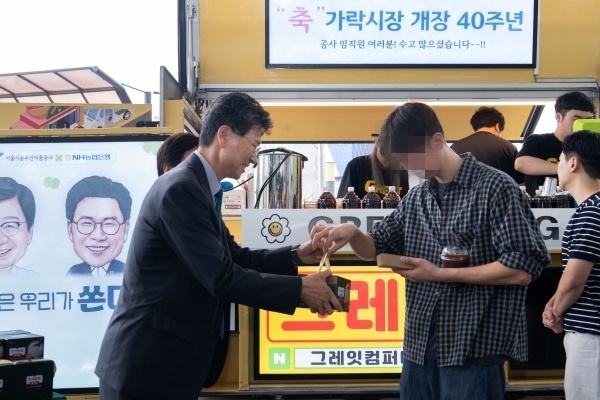 강태영 NH농협은행장(왼쪽)이 가락시장 개장 40주년 기념행사에서 쌀 소비촉진 홍보활동 일환으로 농협 즉석밥을 나눠주고 있다. 사진ㅣNH농협은행