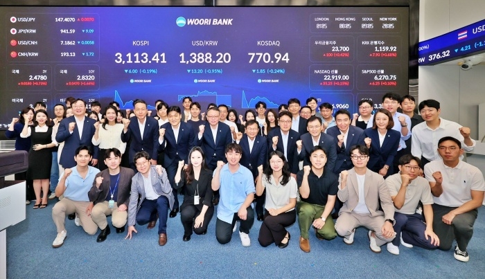 4일 열린 우리은행 본점 자금시장그룹 딜링룸 전광판 점등식에서 정진완 은행장(두번째줄 가운데)과 임직원이 기념촬영하고 있다. 사진ㅣ우리은행