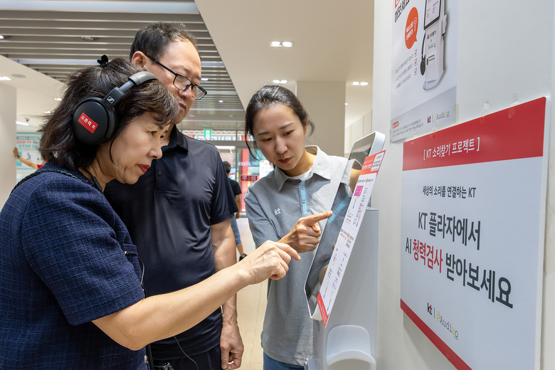 KT플라자를 방문한 고객이 KT 직원으로부터 AI 청력검사 키오스크의 사용법에 대한 설명을 듣고 있다. 사진|KT