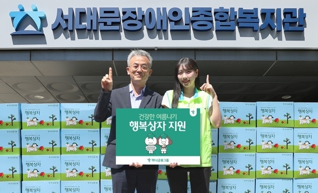 하나금융그룹 직원이 송용성 서대문장애인종합복지관장(왼쪽)에게 행복상자를 전하고 있다. 사진ㅣ하나금융그룹