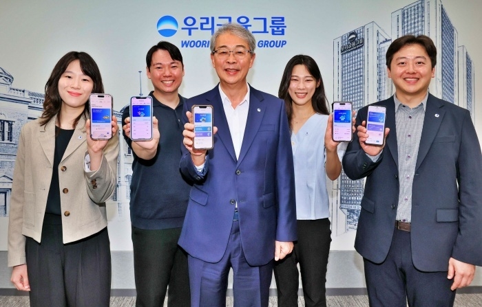 임종룡 우리금융그룹 회장(가운데)이 유니버설뱅킹 신규가입자 100만 돌파를 직원들과 함께 기념하고 있다. 사진ㅣ우리금융그룹