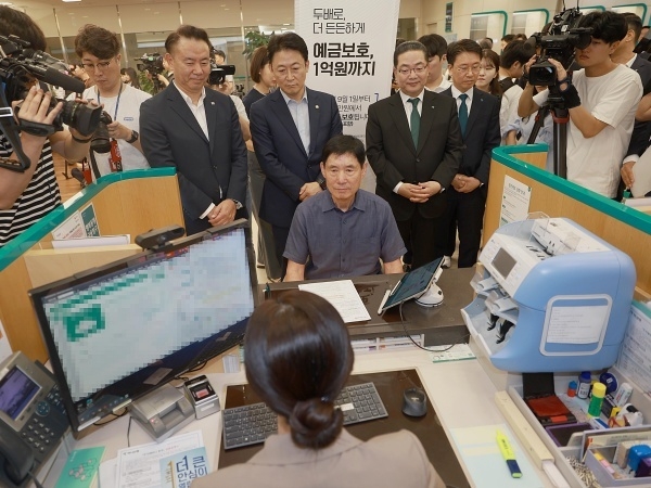 권대영 금융위원회 부위원장이 예금보호한도 1억원 시행 첫날인 1일 하나은행 본점 영업점을 찾아 유재훈 예금보험공사 사장, 이호성 하나은행장과 함께 한 소상공인이 예금상품에 가입하는 모습을 지켜보고 있다. 사진ㅣ금융위원회