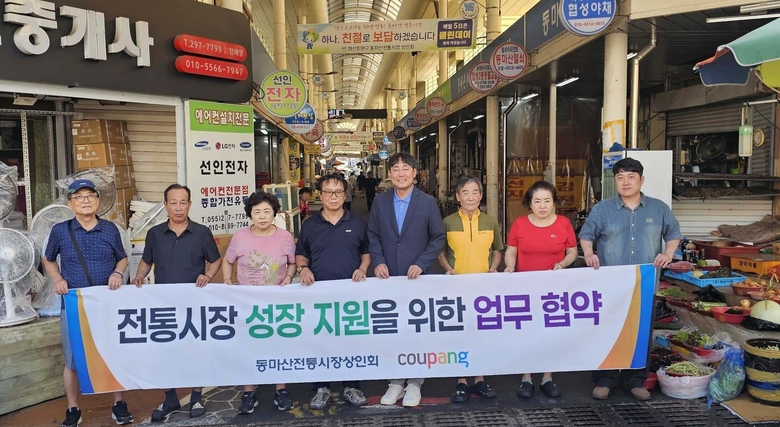 윤상수 동마산 전통시장 상인회장(왼쪽 네 번째), 김종춘 쿠팡 서비스정책실 상무(왼쪽 다섯 번째), 시장상인들이 업무 협약 후 기념 촬영하고 있다.