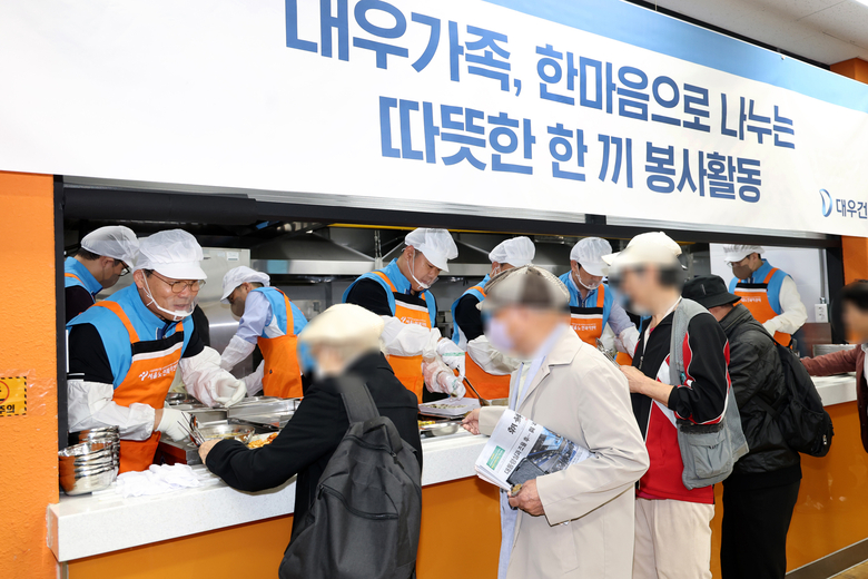 대우건설 김보현 대표이사(왼쪽)와 심상철 노동조합 위원장(오른쪽)이 무료 급식 봉사활동에 참여하고 있다. 사진ㅣ대우건설 